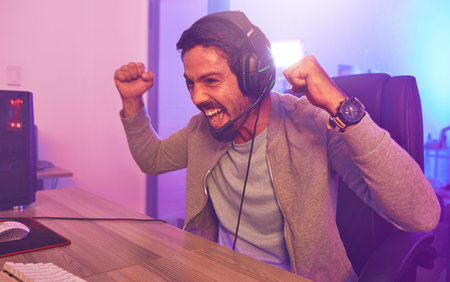Winner, achievement or man gamer on computer with microphone celebrating game win and success fist....