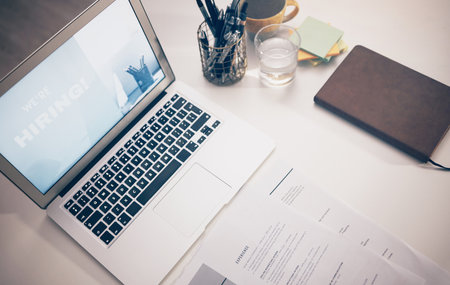 Hiring, job advertising with laptop, marketing and opportunity, recruitment and human resources. Poster, call for new staff and business, resume on desk and onboarding, hr and communication top viewの写真素材