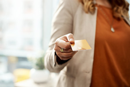 Ill be paying with card. an unrecognizable businesswoman holding a credit card in her office.の写真素材