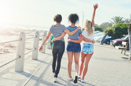 Off into the sunshine. three friends spending the day together on a sunny day.の写真素材