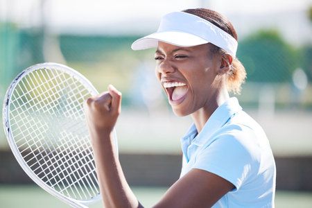 Winner, tennis and celebration of black woman on court after winning match, game or competition. Achievement, success and happy or excited female athlete celebrate sports, workout or exercise goals.の写真素材