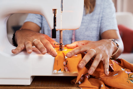 It was love at first sew. an unrecognizable woman making a garment at home.