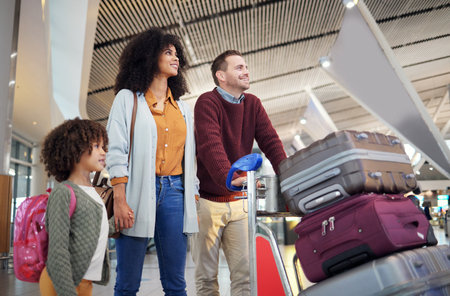 Travel, airport and happy family with luggage for holiday, vacation or immigration for international journey. Suitcase, bag and black woman or diversity parents with child or kid walking togetherの写真素材