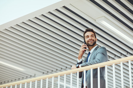 Its been good talking to you. a young businessman talking on a cellphone in an office.の写真素材