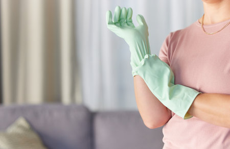 Woman, hands and gloves in housekeeping preparation for cleaning, dirt removal or disinfection in living room at home. Hand of cleaner ready to start spring clean service for safety with rubber gloveの写真素材