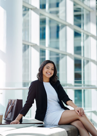 Im ready to knock on success door. Cropped portrait of an attractive young businesswoman smiling while sitting in a waiting room.の写真素材