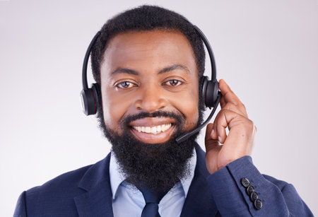 Call center, microphone and portrait of man, studio and consulting questions for customer service. Happy black male, telemarketing consultant and contact us for telecom sales, smile and crm advisoryの写真素材
