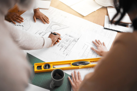 Hands, collaboration and construction with a building team working in their office on design from...