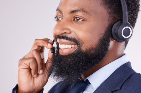 Call center, smile and face of black man with microphone for crm questions, sales consulting and help. Happy male telemarketing consultant in studio for contact, telecom and friendly customer supportの写真素材