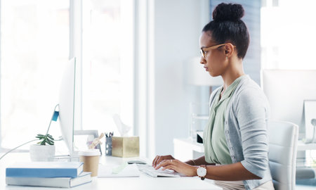 Shes dedicated to reaching her goals. an attractive young businesswoman working at her desk in a modern office.の写真素材