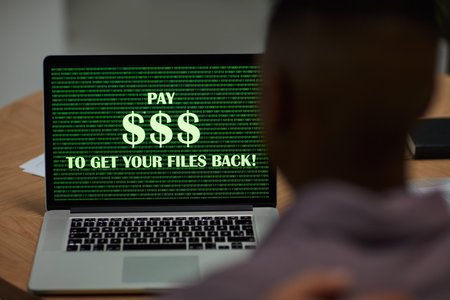 The threat of phishing is real. a businessman using a laptop with the words pay $$$ to get your files back on the screen.の写真素材