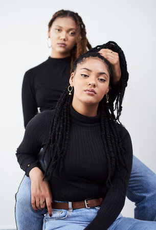 They empower each other. Studio shot of two beautiful young women posing against a grey background.の写真素材