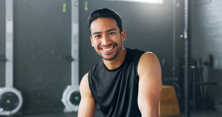 Fitness, exercise and laughing with a man in a gym for a workout or training to get strong or healthy. Wellness, smile and portrait with a happy young male athlete in a health club for exercisingの写真素材