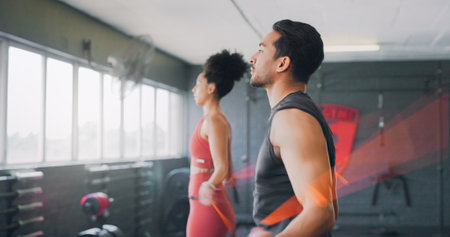 Fitness, couple and skipping with rope in gym for exercise, training or cardio workout together indoors. Active man and woman in healthy jump roping for sports energy, exercising or endurance insideの写真素材