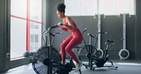 Exercise bike, cardio and girl cycling for sports fitness, athlete marathon training or high energy...