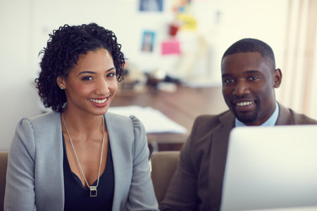 They make a great team in the office. Portrait of a young businessman and businesswoman in the office.の写真素材