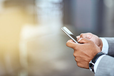 He keeps the smartest connections close by. Closeup shot of an unrecognizable businessman using a cellphone in an office.の写真素材