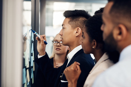 Plan first then put it into action. a group of young businesspeople having a brainstorming session together in a modern office.の写真素材