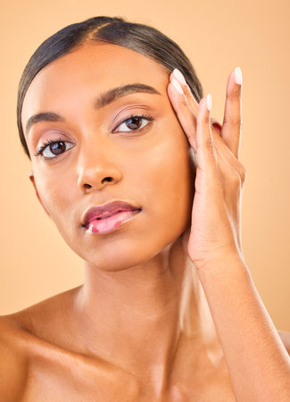 Skincare, face portrait and beauty of woman in studio isolated on brown background. Natural makeup, cosmetics and confident Indian female model with spa facial treatment for healthy or flawless skin.の写真素材