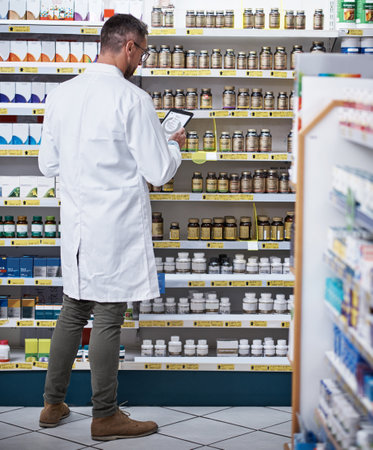 Modern tech for a modern pharmacist. a mature pharmacist using a digital tablet in a pharmacy.の写真素材
