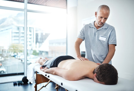 Well slowly reduce and eliminate this pain. a physiotherapist treating a patient.の写真素材