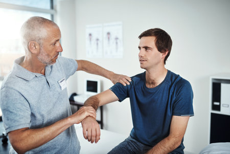 Thats exactly where the pain is. a physiotherapist treating a patient.の写真素材