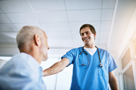 Theres nothing to fear when Im here. a male nurse caring for a senior patient.の写真素材