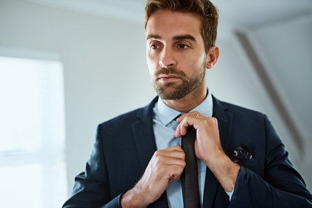 Dress good, do good. a handsome young man dressing himself at home.の写真素材