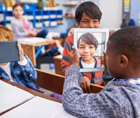 This is my best friend. elementary school children using a tablet in class.の写真素材