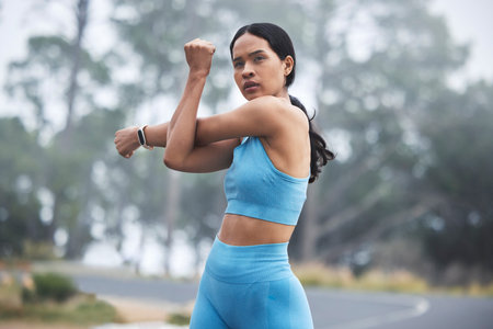 Arm stretching, woman focus and runner exercise on a outdoor road in the mountains in morning....