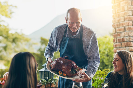 Dad always knew how to make a great turkey. a man bringing a freshly cooked turkey to the dining table.の写真素材