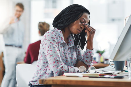 This isnt working out for me. a young woman suffering from stress while using a computer at her work desk.の写真素材