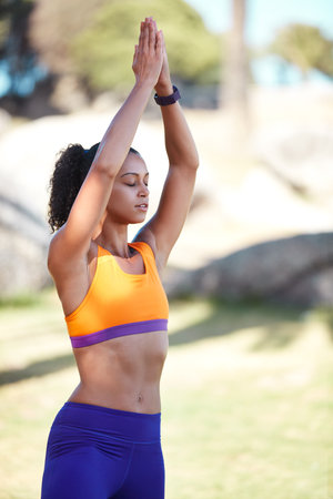 Focus on being a better version of yourself. an attractive young woman practising yoga at a park.の写真素材