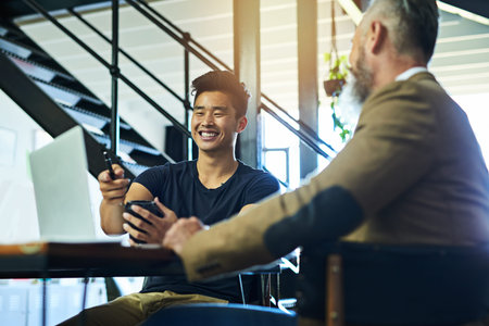 Success has got them smiling broadly. two businessmen having a meeting in an office.