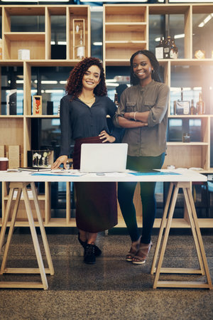 Were ready to make some moves. Portrait of two designers standing together in a modern office.の写真素材