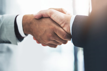 And just like that, the deal is struck. two unrecognizable businessmen shaking hands after making a deal in the office.の写真素材