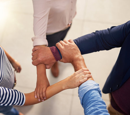 Linking in for success. a group of unrecognizable businesspeople joining their hands in a gesture of unity.の写真素材