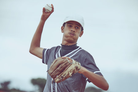 Baseball, sports and fitness with a man athlete throwing a ball during a game or match outside. Workout, training and exercise with a male baseball player playing a competitive sport for healthの写真素材