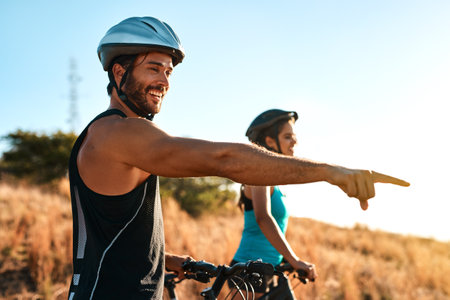 Mountain bikers breathe in fresh air, not pollution. a happy young couple out mountain biking together.の写真素材
