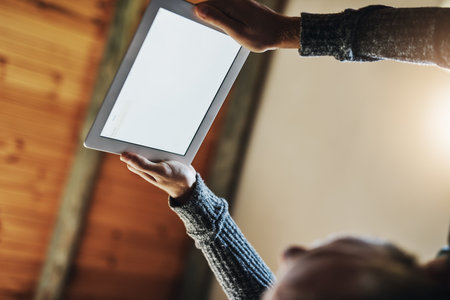 Watching some of my favourite videos. Low angle shot of a young man using his digital tablet while relaxing in bed at home.の写真素材