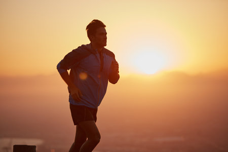 Commit to be fit. a silhouetted young man out for a run at sunrise.の写真素材