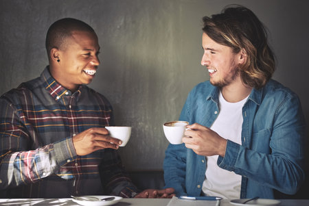 Theres always time for coffee. two friends having coffee together in a coffee shop.の写真素材