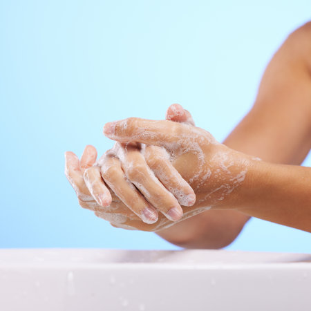 Soap, girl or washing hands in studio on blue background for wellness or healthy skincare hydration. Healthcare mockup, body care zoom or woman cleaning with liquid for hygiene or bacteria preventionの写真素材
