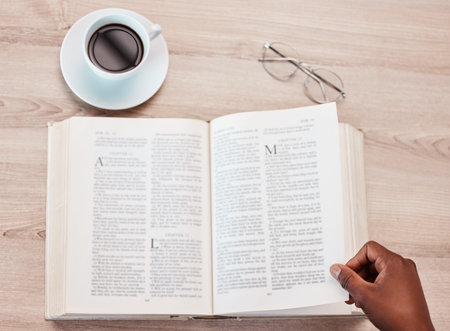 Hand, bible and a person reading in a coffee shop for religion, belief or faith in god and jesus....