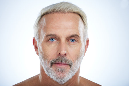 Old man, face and serious with beauty and grooming, hygiene and skin isolated on studio background. Portrait, facial and mockup space with senior male, anti aging cosmetic care and dermatologyの写真素材