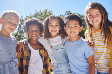 Friendship, kids and portrait of friends in a park playing together outdoor in nature. Happiness, diversity and children with a smile standing, embracing and bonding in a outside garden or playgroundの写真素材