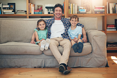 Our favourite time is family time. Portrait of a happy family relaxing on the sofa together at home.の写真素材