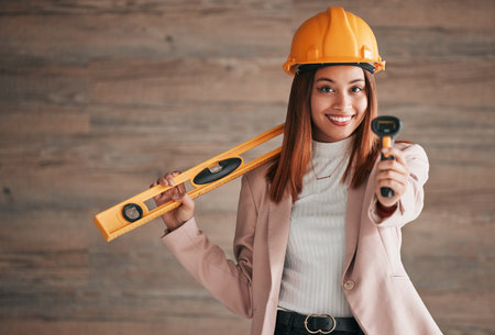 Architect, business woman and portrait of a property management worker with construction tools. Safety helmet, smile and stud detector for a home renovation project with a happy female employeeの写真素材