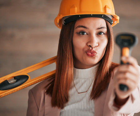 Engineer pout, business woman and portrait of a property management worker with construction tools. Safety helmet and stud detector for a home renovation project with happy and silly female employeeの写真素材