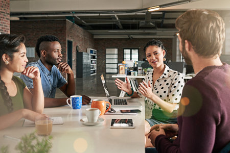 Shes taking the initiative on their project. a team of colleagues having a meeting in a modern office.の写真素材